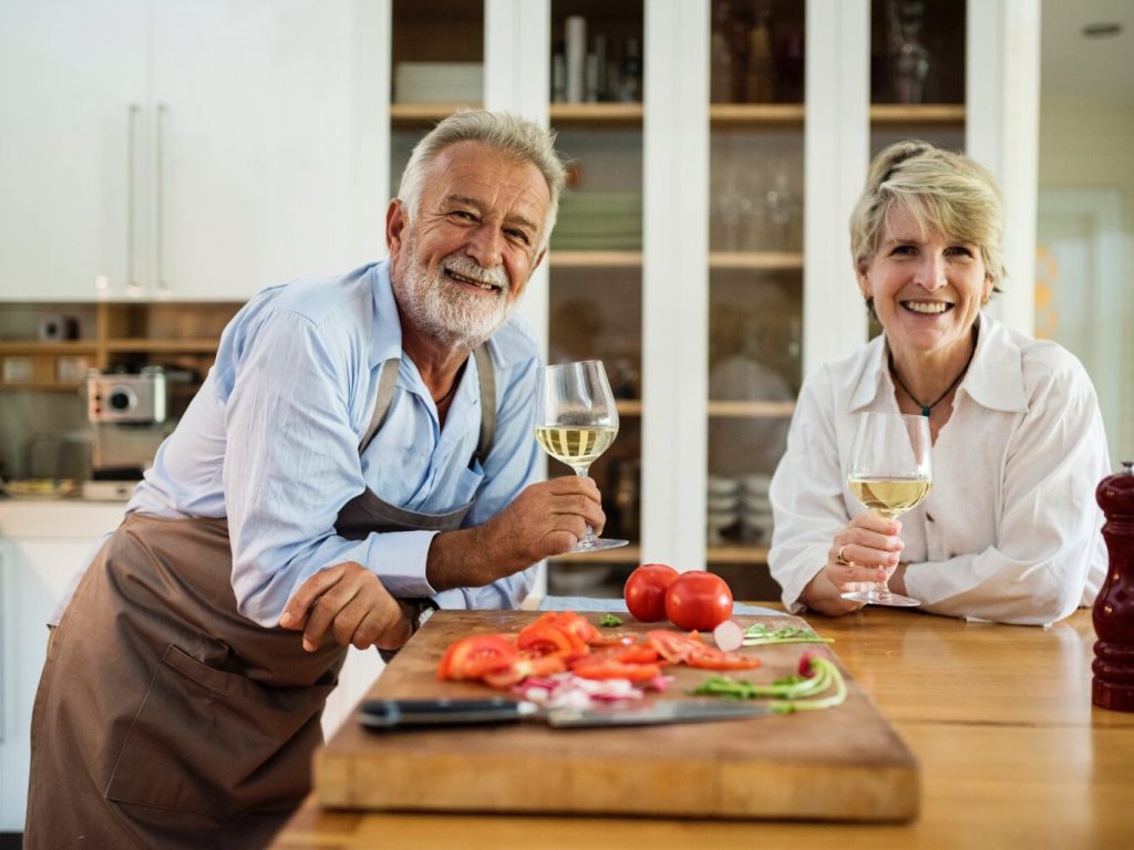 An older couple smiling in their home