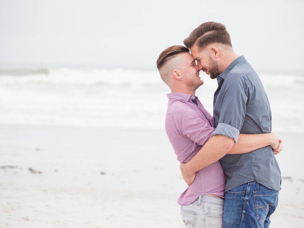 Close up image of a same sex or Gay male couple being loving and happy on the beach in Cape Town South Africa